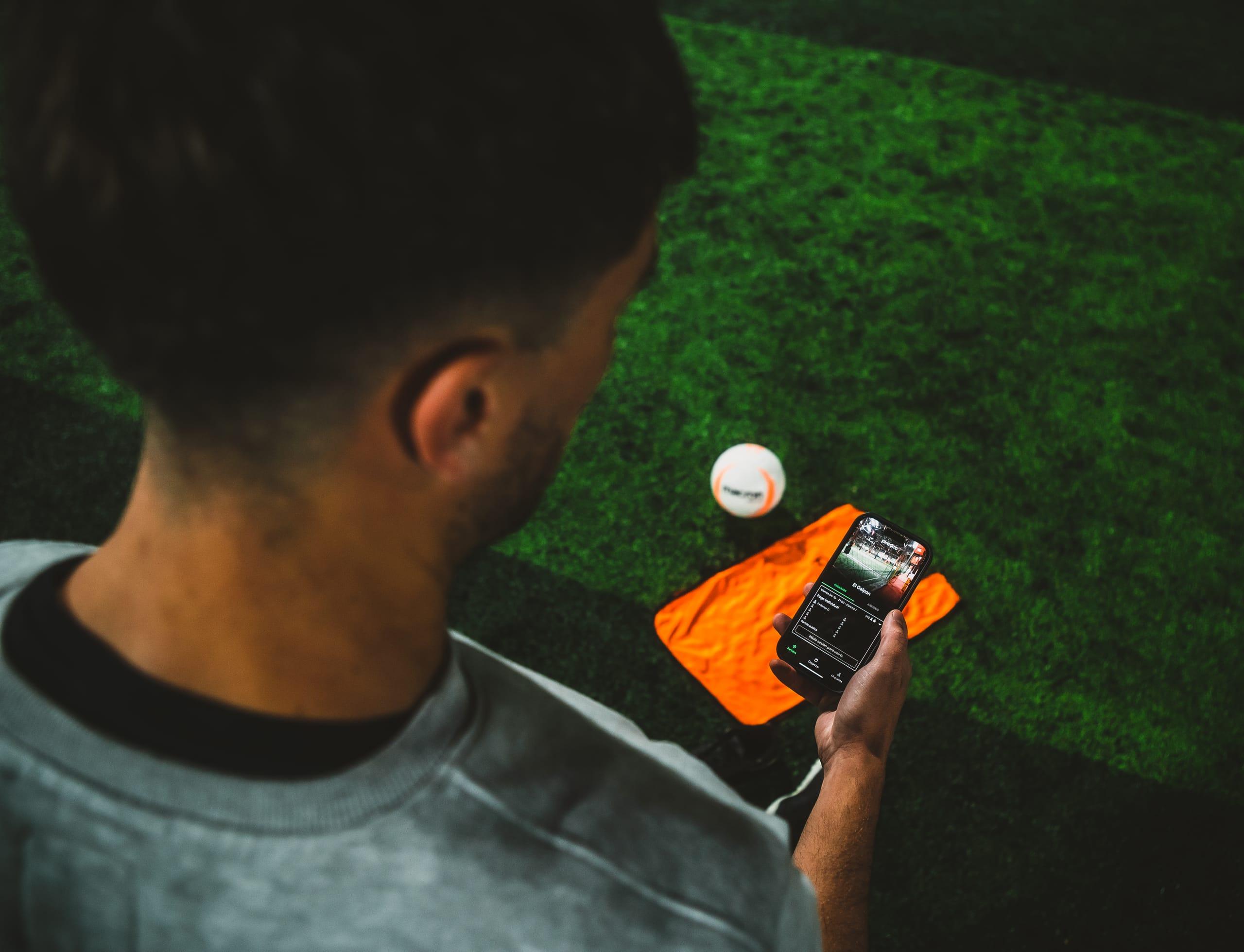 Jugador con pechera naranja de picadito encarando la jugada bajo los focos del galpón